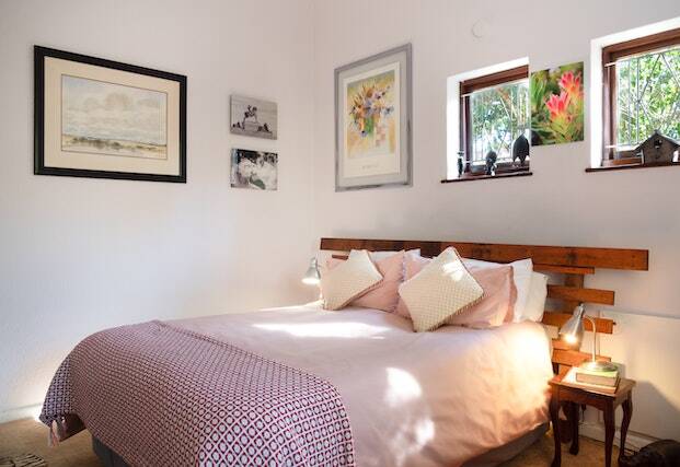 Bedroom with painting on the wall and dark wood bed frame